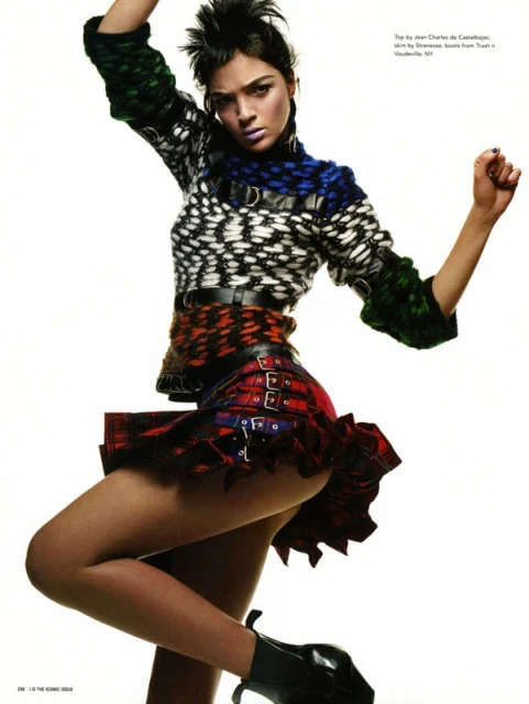 A fashion shot features a stylish adult female wearing a colorful knit top, plaid skirt, and black ankle boots against a white backdrop.