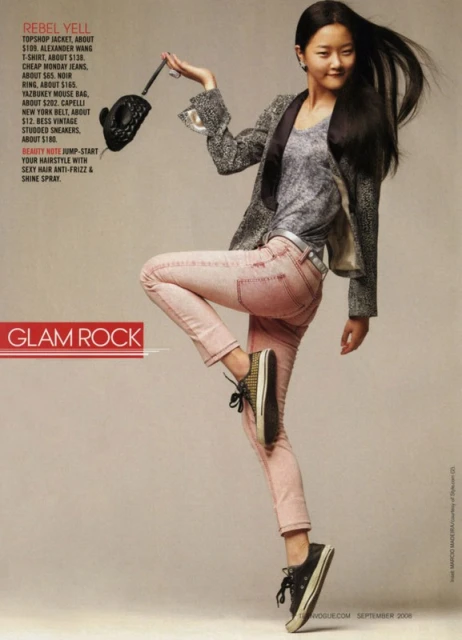 Full-length fashion shot of an Asian model in pink jeans and a jacket, striking a dynamic pose, holding a black purse with text overlay.