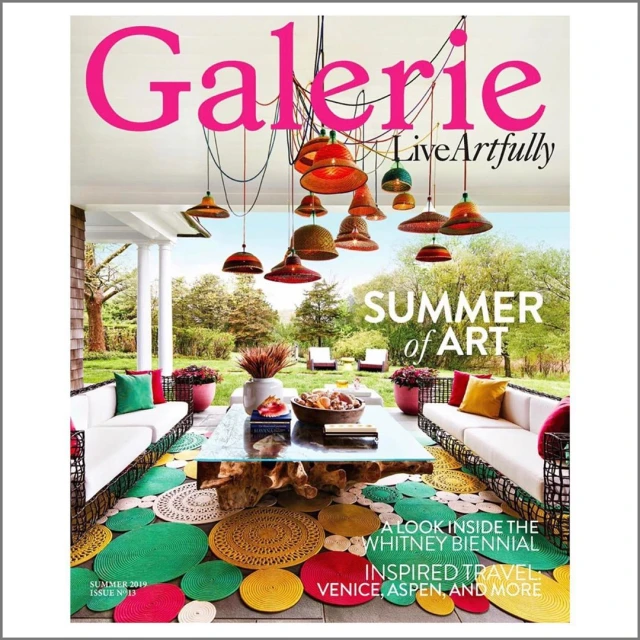 Magazine cover featuring an outdoor patio scene with pendant lights, a table setting, and colorful circular rugs, promoting summer art.