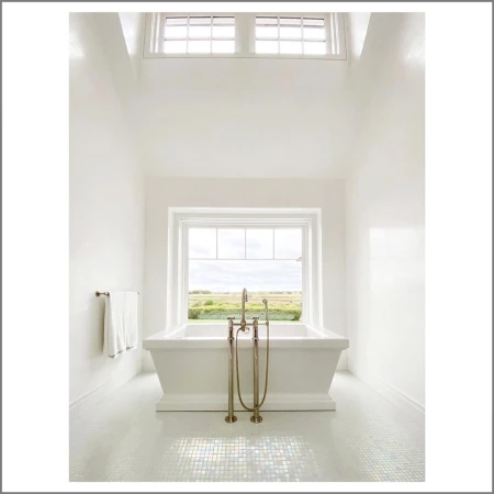 Bright and spacious bathroom interior featuring a white bathtub in front of a window offering a view of a green field landscape.