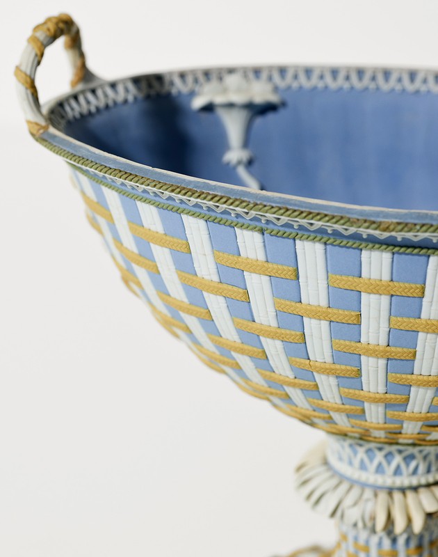 Elegant light blue and white footed bowl featuring woven pattern and delicate ornamentation on a clean white background.