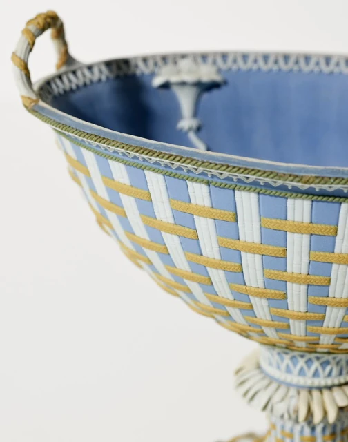 Elegant light blue and white footed bowl featuring woven pattern and delicate ornamentation on a clean white background.