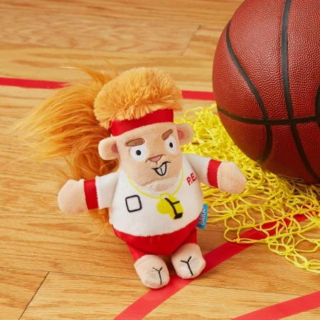 Plush toy animal dressed as a gym teacher with a basketball and net on a wooden floor with red lines, shot in a studio.