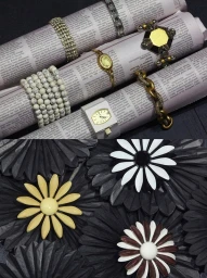 Close-up of bracelets arranged on rolled newspapers and black paper flower sculptures styled by Thomas Tomczak