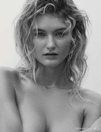 Close-up monochrome portrait of a woman with wet hair and a direct gaze against a plain backdrop.