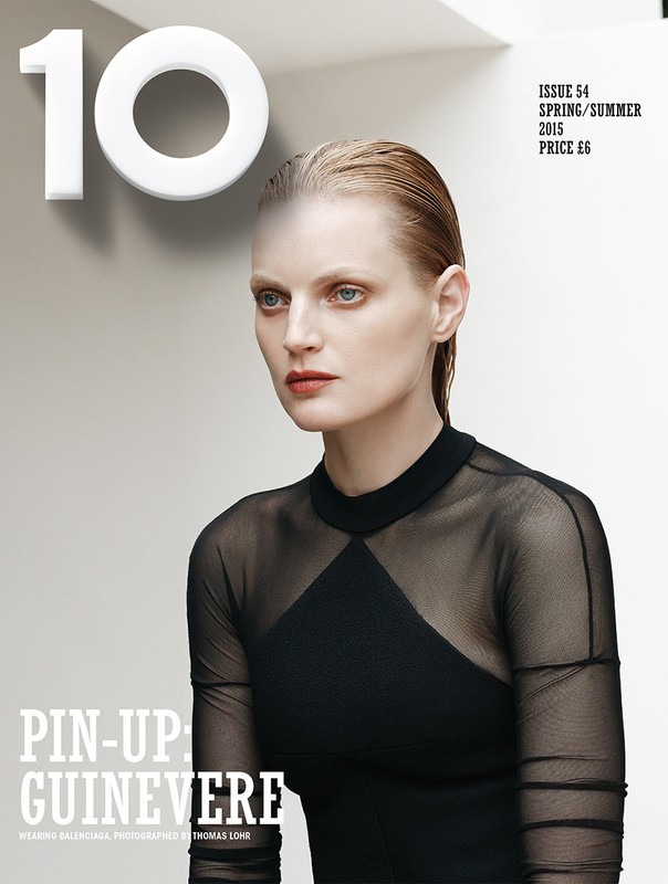 Fashion magazine cover featuring a fair-skinned female model with slicked-back blonde hair, wearing a black sheer top with black dress underneath.