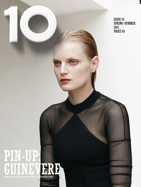 Fashion magazine cover featuring a fair-skinned female model with slicked-back blonde hair, wearing a black sheer top with black dress underneath.