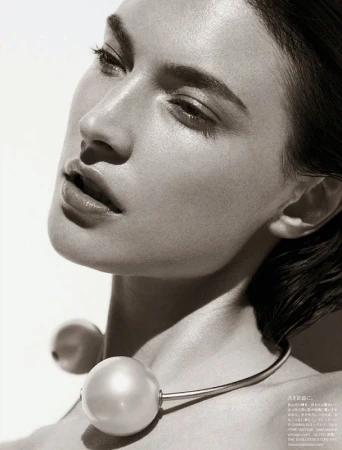 Close-up portrait of a woman wearing a modern metal choker with large white pearl spheres styled by Tuan Anh Tran.