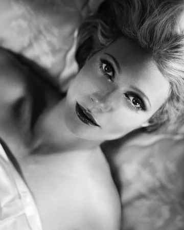 Close up monochrome portrait of blonde woman lying down looking up captured by photographer Vincent Peters