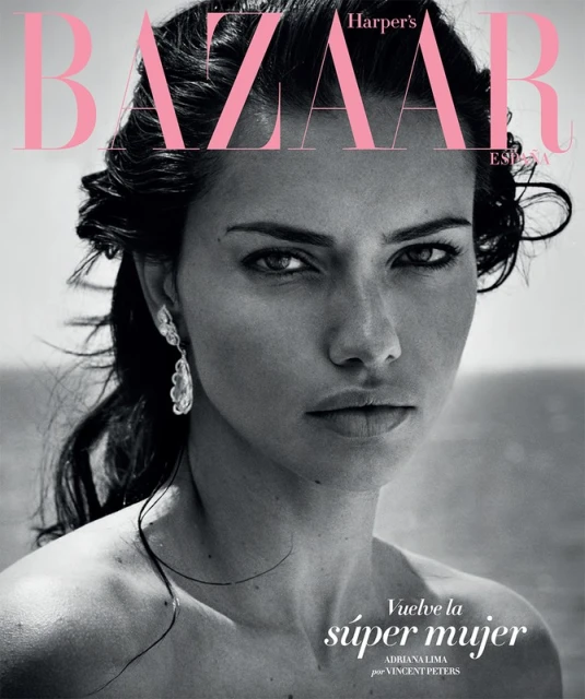 Close-up portrait of a model, Adriana Lima, on the cover of Harper's Bazaar España magazine, with pink and black typography.