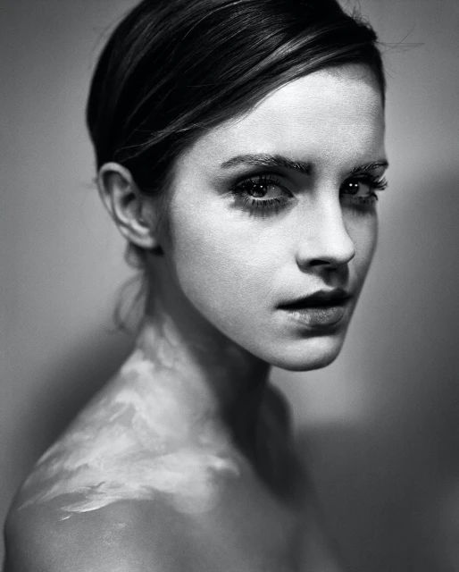 Monochrome portrait of a young fair-skinned woman gazing at the camera, set against a blurred background with atmospheric lighting effects.