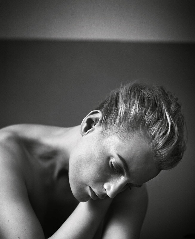 Black and white portrait of a woman with short blonde hair looking down thoughtfully by photographer Vincent Peters