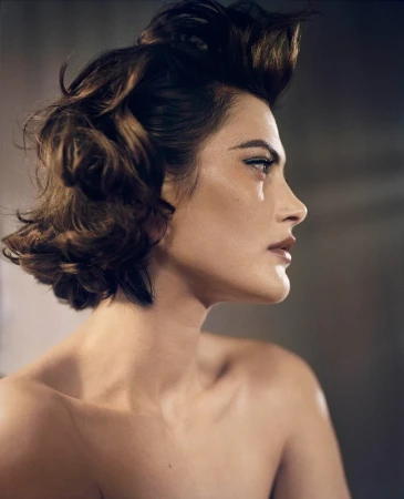 Profile portrait of a woman with dark wavy hair in a side view by photographer Vincent Peters
