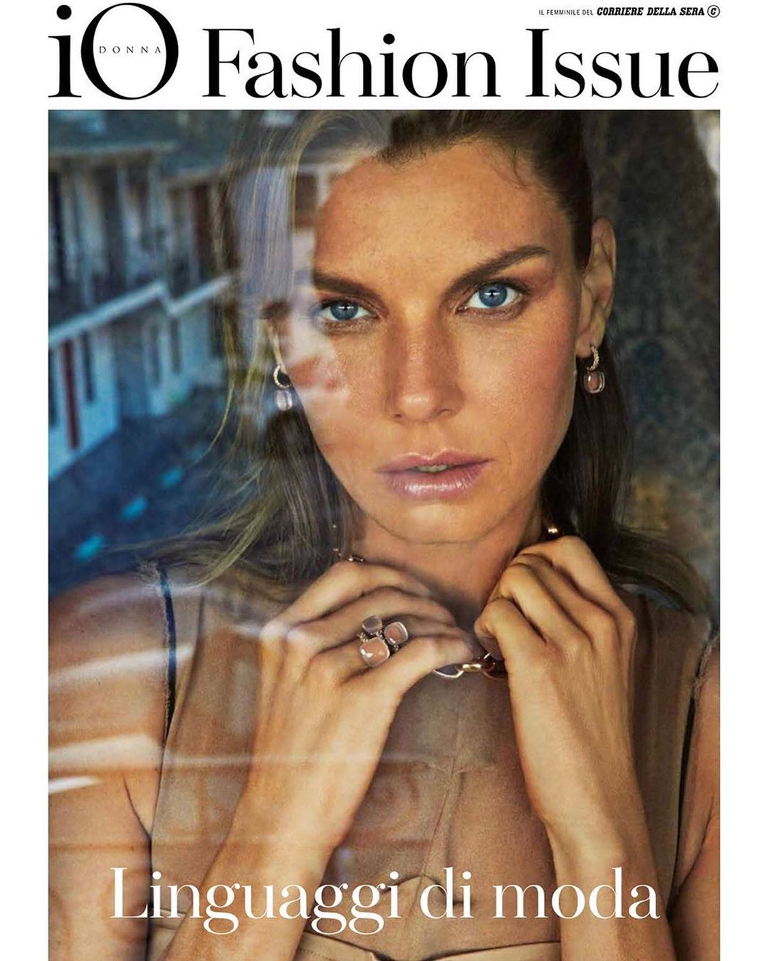 Fashion magazine cover featuring a close-up of a woman with blue eyes, fair skin, wearing jewelry and a beige sleeveless top.