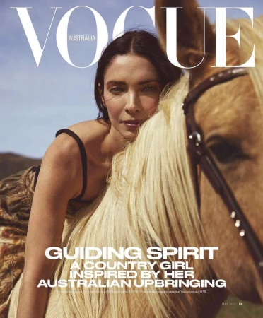 Woman leaning against a blonde horse under a clear sky, captured in a portrait for Vogue Australia by Williams + Hirakawa.