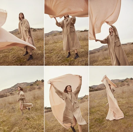 Composite photo of a model in a beige trench coat lifting a large pink fabric outdoors in a dry grassy meadow.
