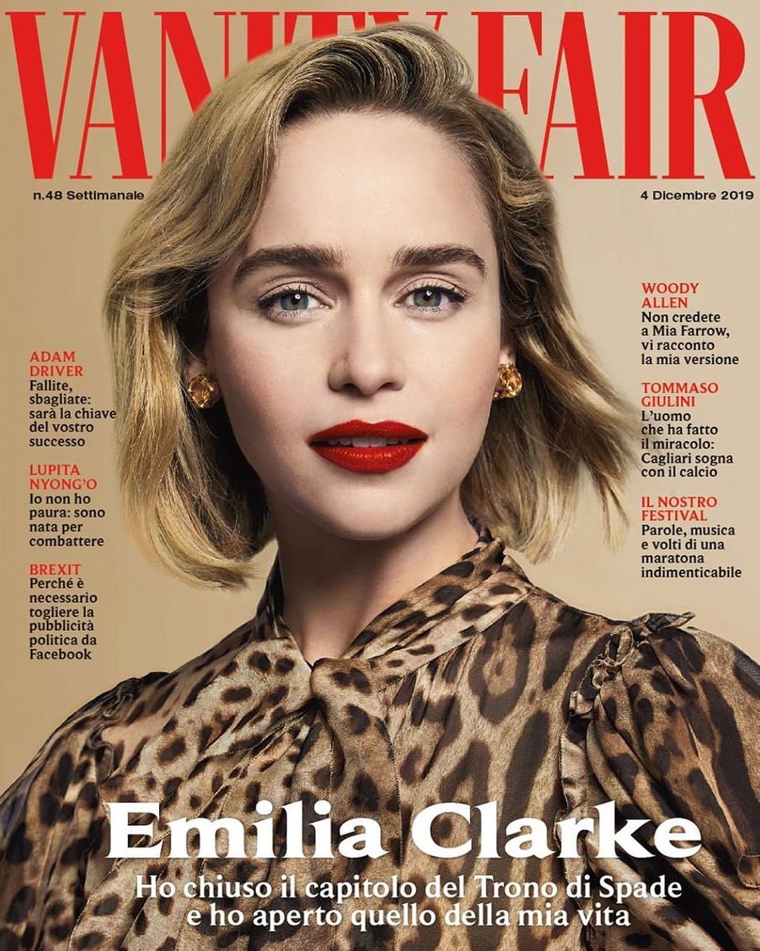 Emilia Clarke is featured on the cover of Vanity Fair magazine, wearing a leopard print top, her hair styled in loose waves, and vibrant red lipstick.