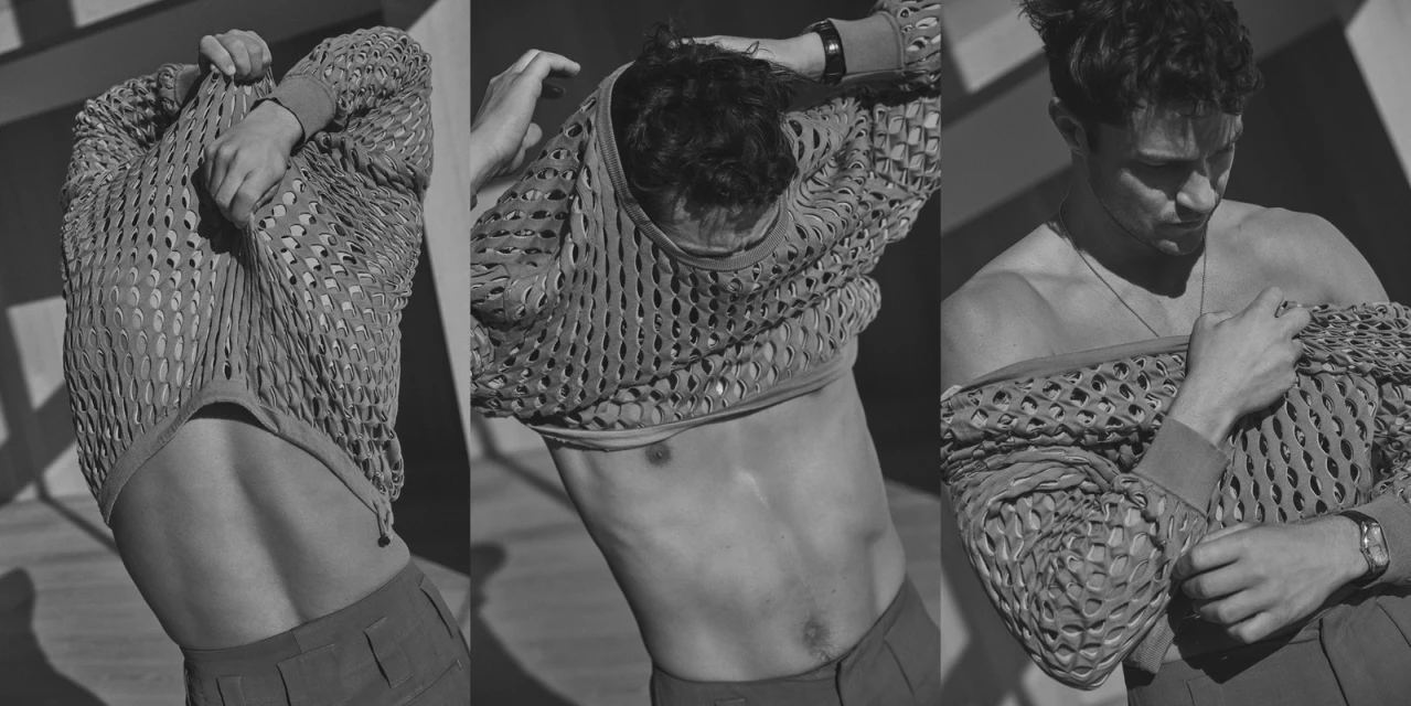 Black and white triptych shows a man taking off a fishnet sweater, exposing his torso. Indoor studio lighting, neutral color palette.