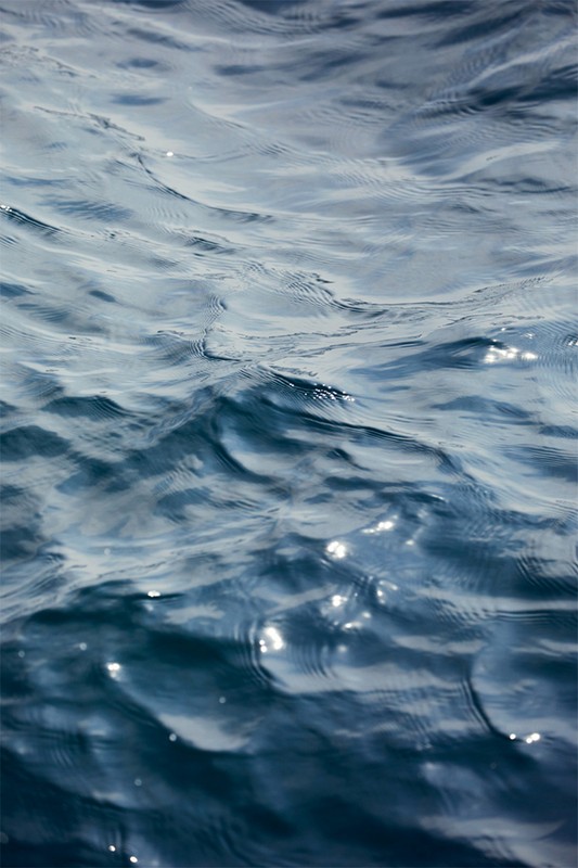 Close-up of deep blue sea water with sunlit surface, creating a tranquil and mesmerizing natural abstract pattern.