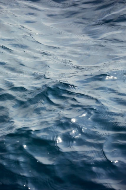Close-up of deep blue sea water with sunlit surface, creating a tranquil and mesmerizing natural abstract pattern.