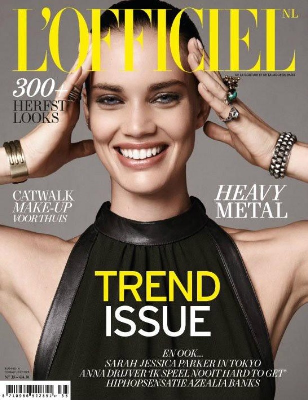 Magazine cover featuring a smiling woman with jewelry, wearing a black top against a neutral background. 'L'Officiel' logo is at the top.