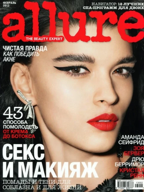 Close-up of a magazine cover featuring a woman with bold winged eyeliner and red lipstick; the title 'allure' is in large red letters.