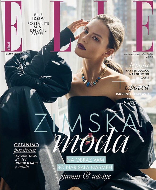 Elle Slovenia cover featuring a model in a black dress with statement sleeves and bold jewelry, set against a blurred window backdrop.