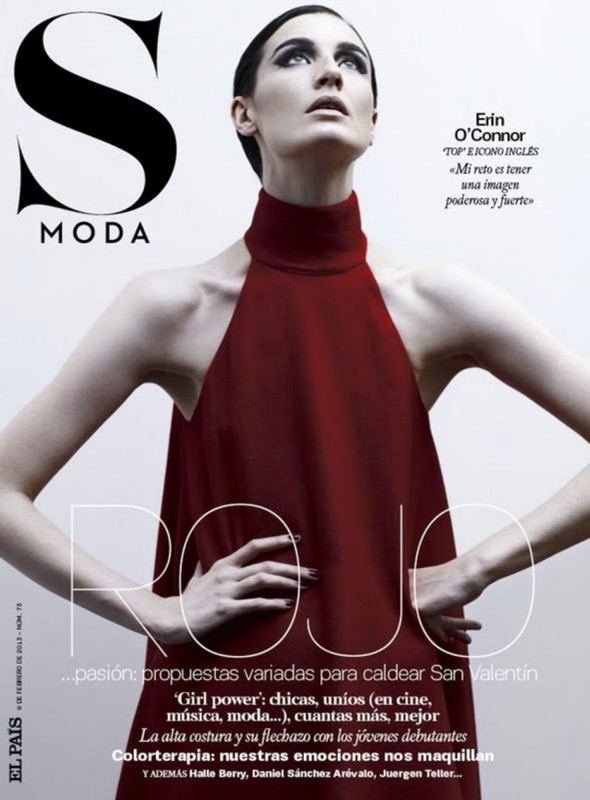 Magazine cover featuring a female model with dark hair wearing a red dress, looking upwards with neutral expression and hands at her waist.