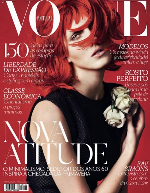 Vogue Portugal cover featuring a red-haired model in a black dress, holding white flowers, against a red background with magazine text.