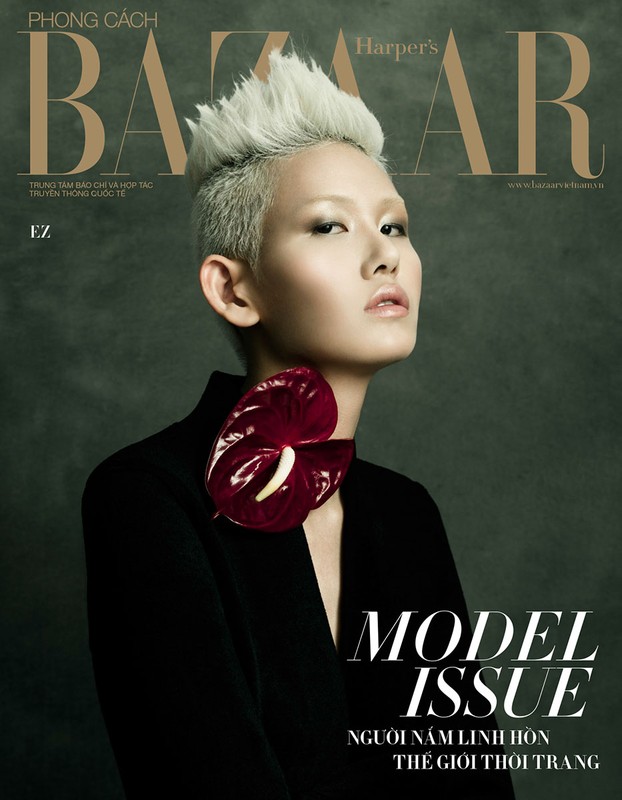 Fashion magazine cover featuring an Asian woman with platinum blonde hair, wearing a black jacket and red flower brooch against a green background.