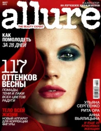 Close-up magazine cover featuring a woman with dark teal eyeshadow, pink lipstick, and a draped red hood.
