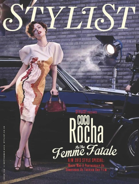 Fashion magazine cover featuring a woman in a dress, holding a purse, next to a classic car, and photography lighting equipment.