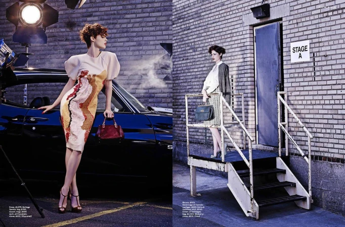 Fashion editorial featuring two female models posing near a car and a building with a door and stairs, lit by studio lights.