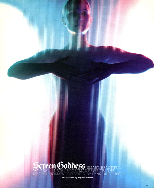 Editorial fashion shot of a slender woman with dark hair, hands clasped, against colorful vertical light bars in a studio setting.