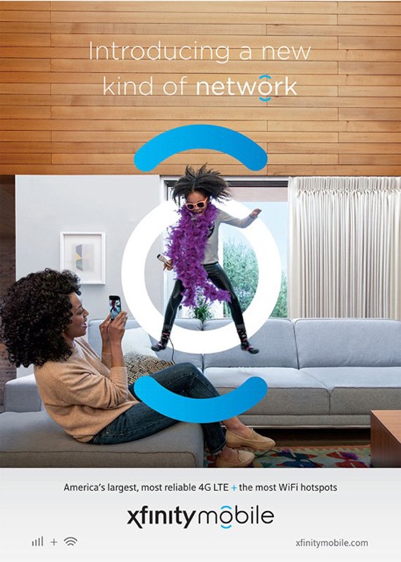 Young girl in feather boa poses for photo taken by woman on sofa in brightly lit living room in an ad for Xfinity Mobile.