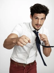 Man in white patterned short-sleeve shirt and red trousers throwing a punch with a dark tie flying sideways