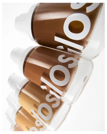 Cosmetic foundation bottles in a row with various shades, showcasing makeup and beauty products, set against a clean, bright white background.