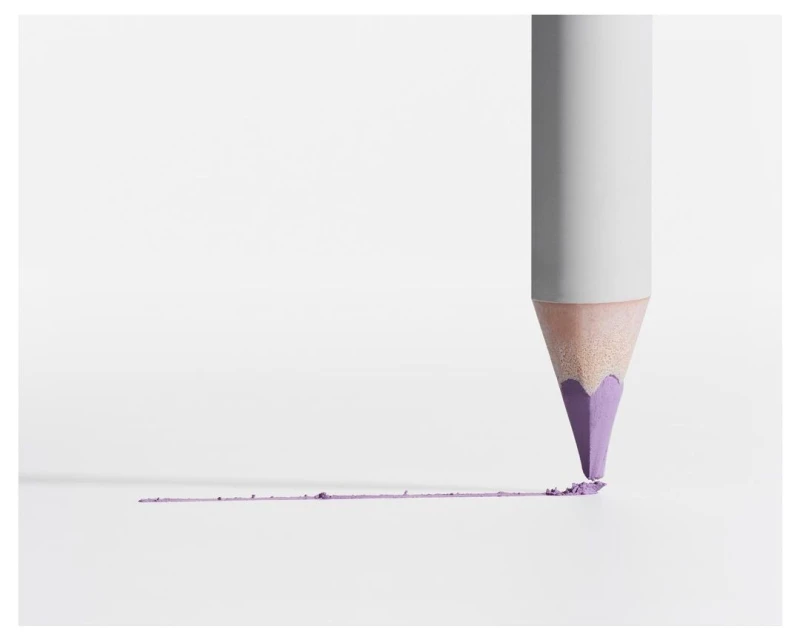 Close-up of a lilac-tipped pencil on white background, drawing a line and leaving a trail of pigment dust. Minimalist beauty or art concept.