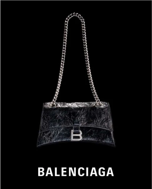 Silver chain-strap handbag with silver hardware and logo against black backdrop; fashion accessory with luxury branding.