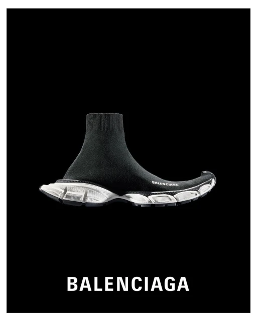 Black Balenciaga sock-style sneaker with white sole on black background. High-fashion footwear, athletic shoe, studio shot.