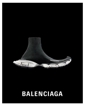 Black Balenciaga sock-style sneaker with white sole on black background. High-fashion footwear, athletic shoe, studio shot.
