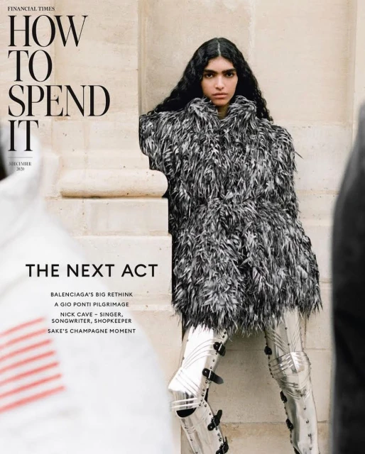 Fashion magazine cover featuring a woman in textured coat and metallic leggings leaning against a wall with text overlay.