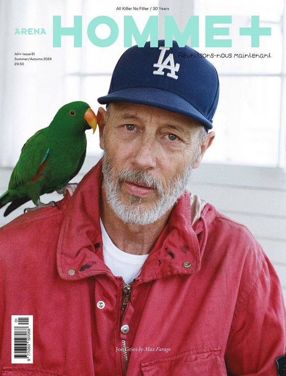Magazine cover featuring a close-up of a mature man with a salt and pepper beard and a green parrot perched on his shoulder.
