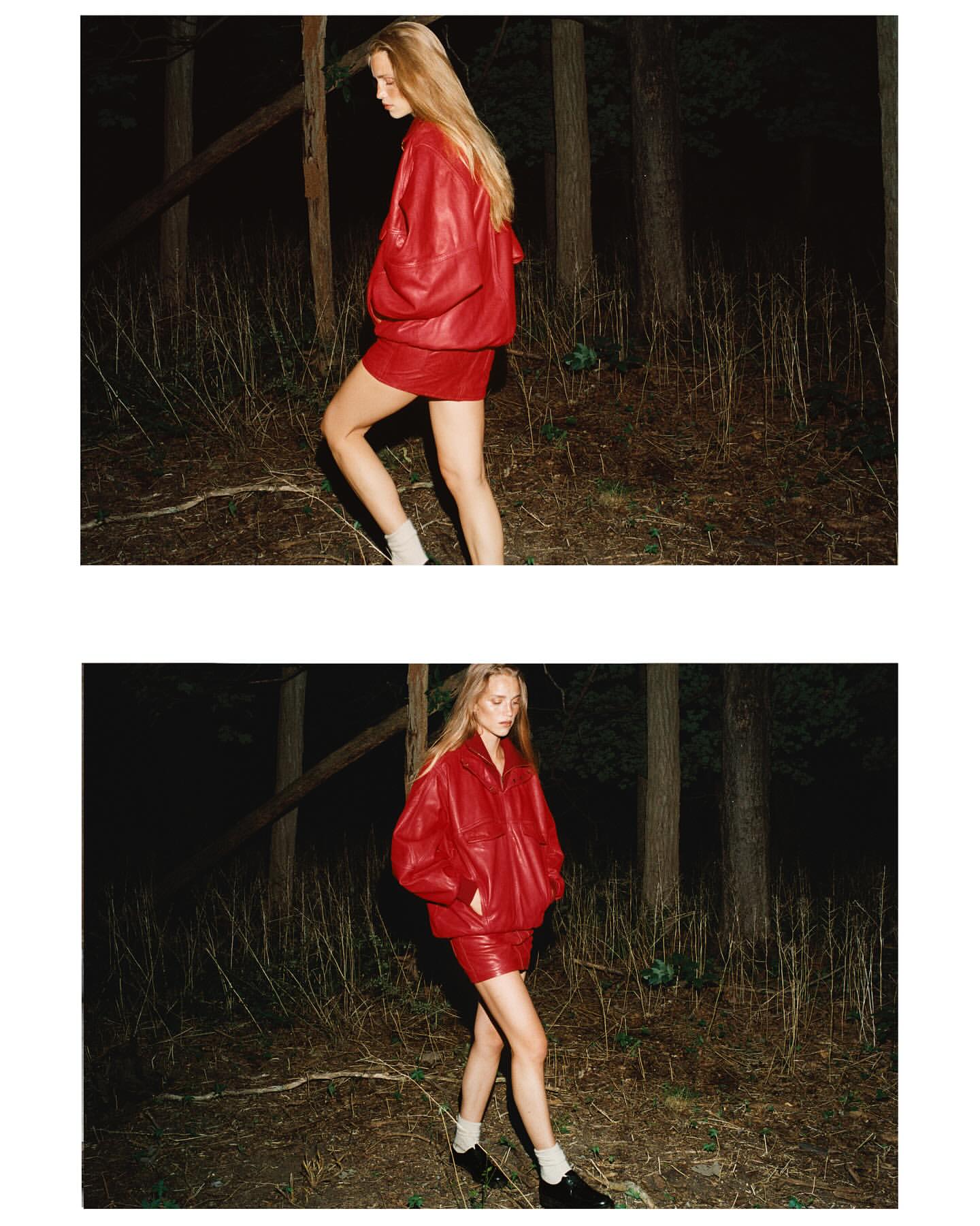Fashionable woman in red leather jacket and skirt walks through forest at night, showcasing dark editorial aesthetic.
