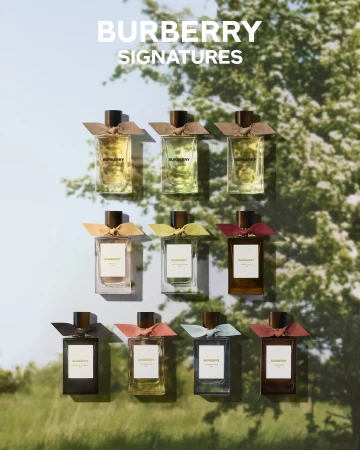 Burberry Signatures fragrance collection featuring nine glass perfume bottles with colorful ribbon accents against an outdoor backdrop.
