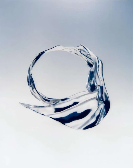 Abstract photographic art of translucent flowing material, evoking movement and fluidity, set against a graduated blue and white background.
