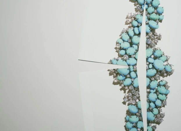 Turquoise and diamond necklace with geometric white paper cutouts on a clean, white background. High-end jewelry with a modern aesthetic.