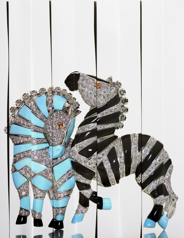 Close-up of two zebra figurines, one teal and diamond, the other black and diamond, standing against a white background with black vertical lines.