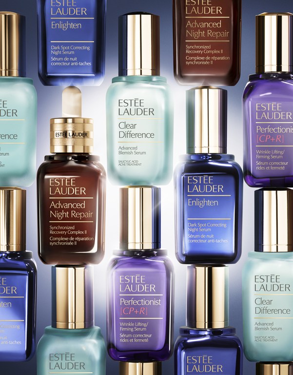 Collection of Estee Lauder skincare products displayed in an organized group, featuring night repair and blemish serums in various colors.