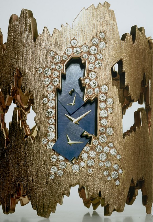 Gold bracelet featuring diamonds and a blue center with birds, studio shot.
